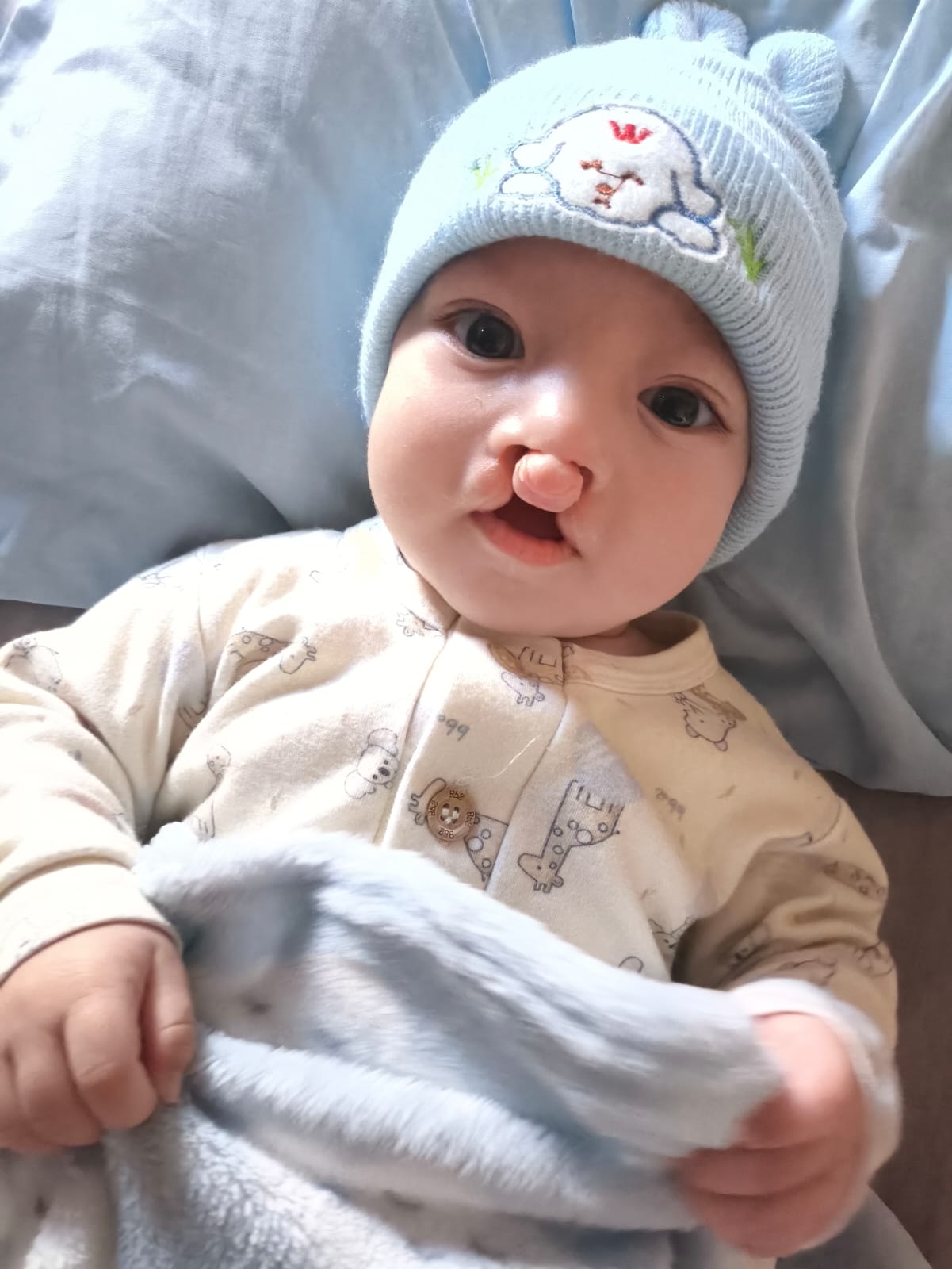 Ravi deitado, usando um gorrinho azul